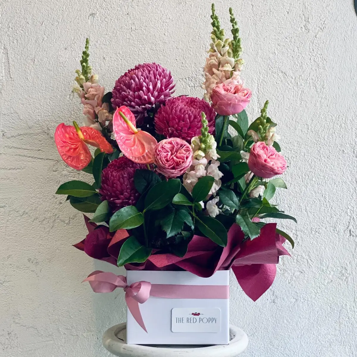 Boxed arrangement of vivid pink and magenta blooms in The Red Poppy gift box