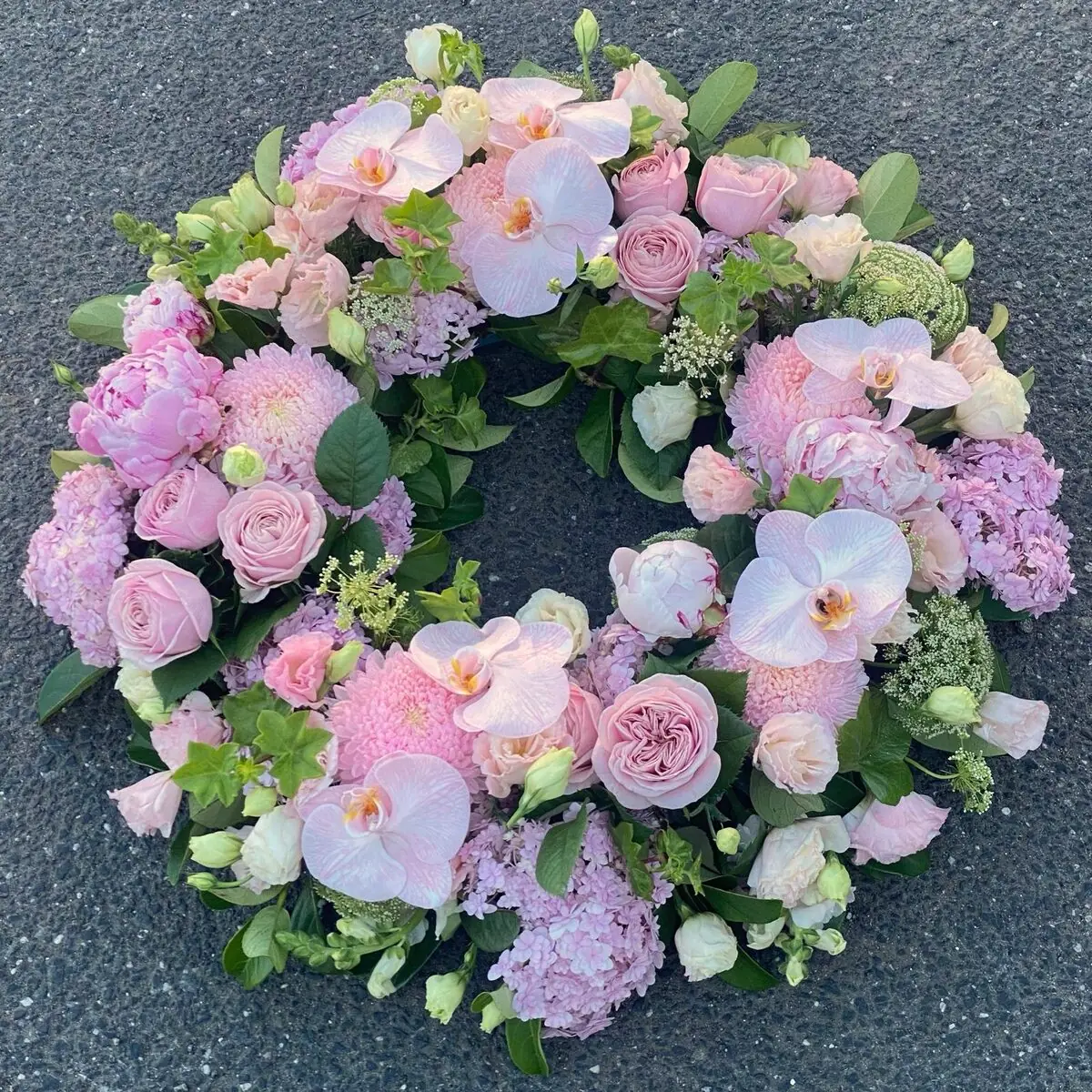 Funeral wreath of soft pink orchids, peonies and roses