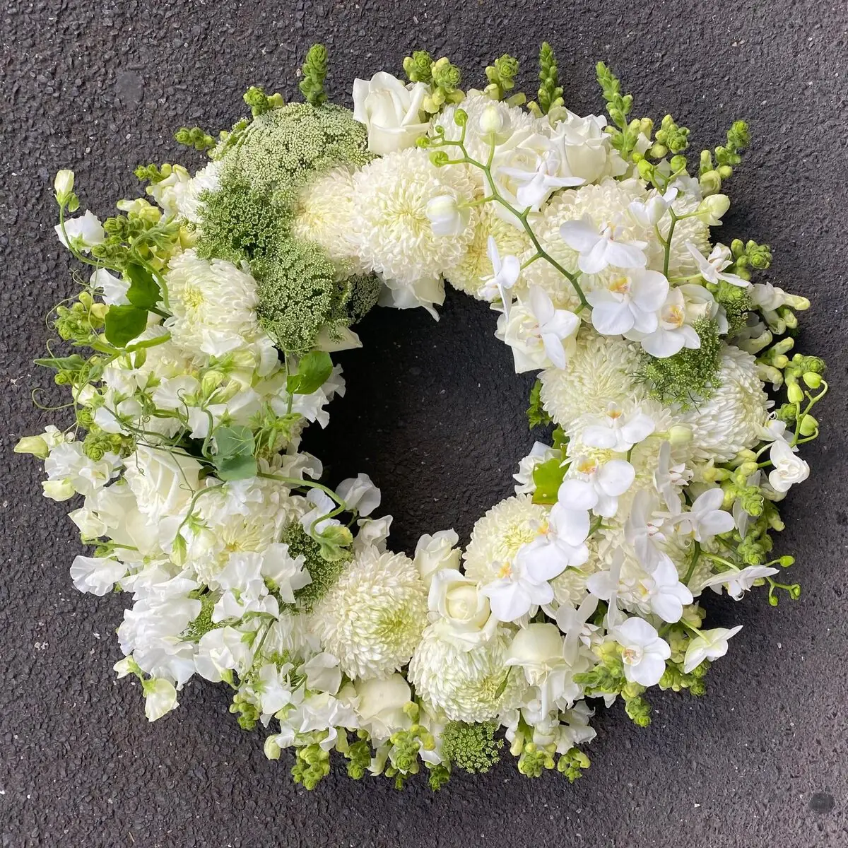 Funeral wreath of white orchids and chrysanthemums