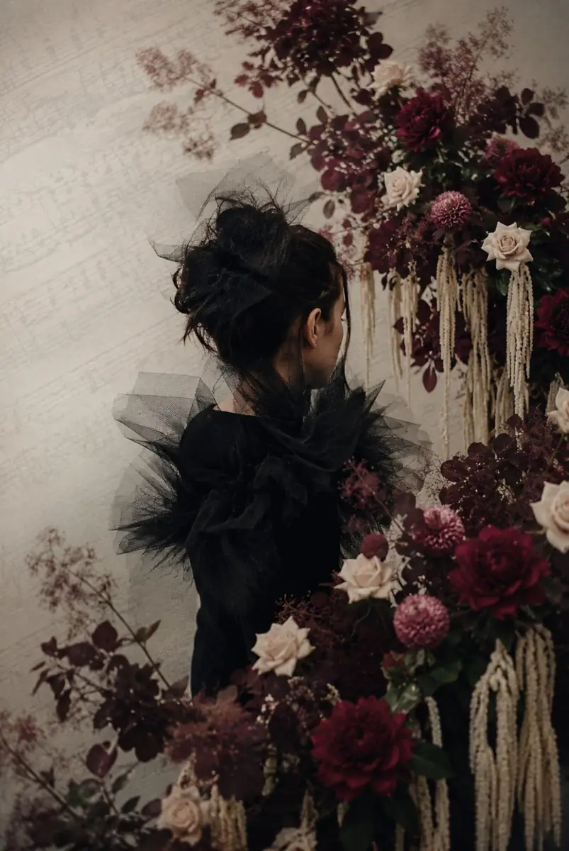 Zoe in black tulle among burgundy dahlias, blush roses and trailing amaranthus